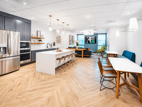 A modern kitchen with wooden floors and a dining table with chairs.