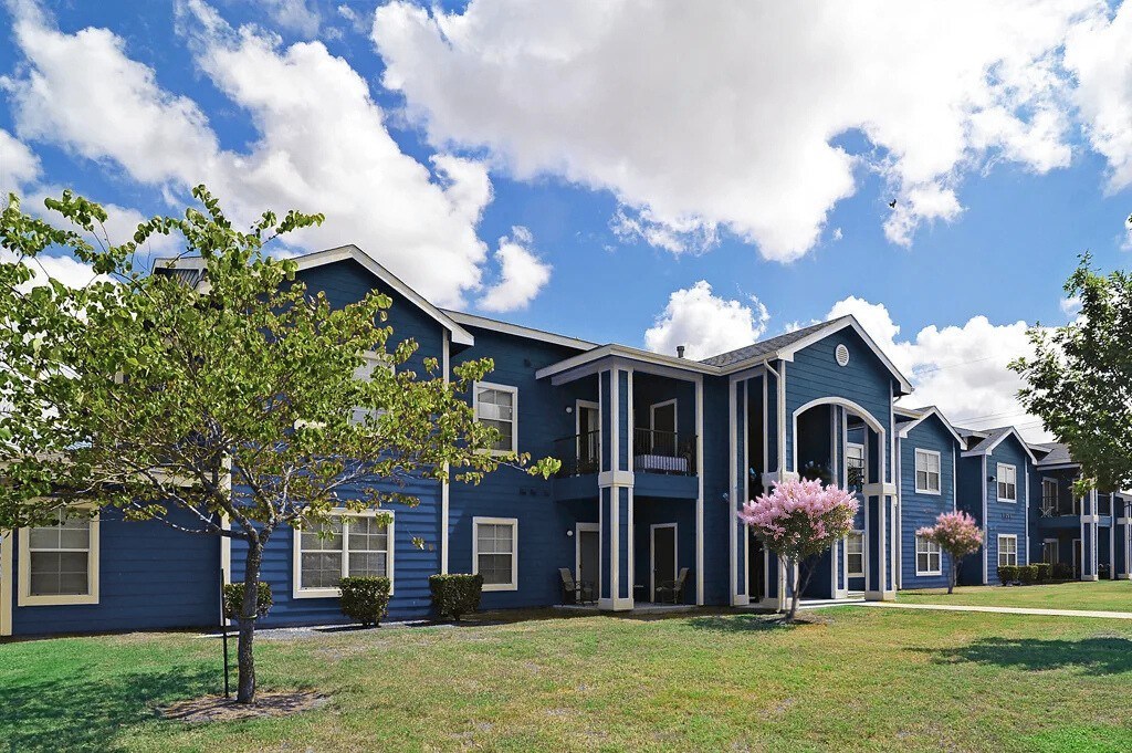 A blue building with a tree in front of it.