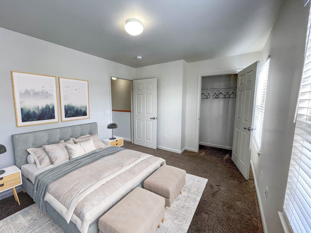 A bedroom with a large bed and two pictures on the wall.