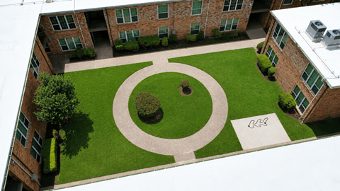 A courtyard with a circular garden and a sign with a wheelchair symbol.