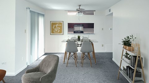 A living room with a grey carpet and a grey chair.