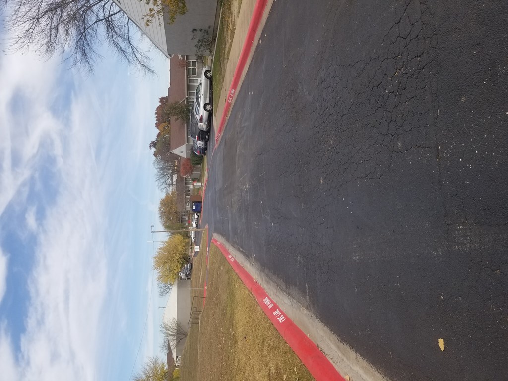 A red line on a black surface with a white car in the background.
