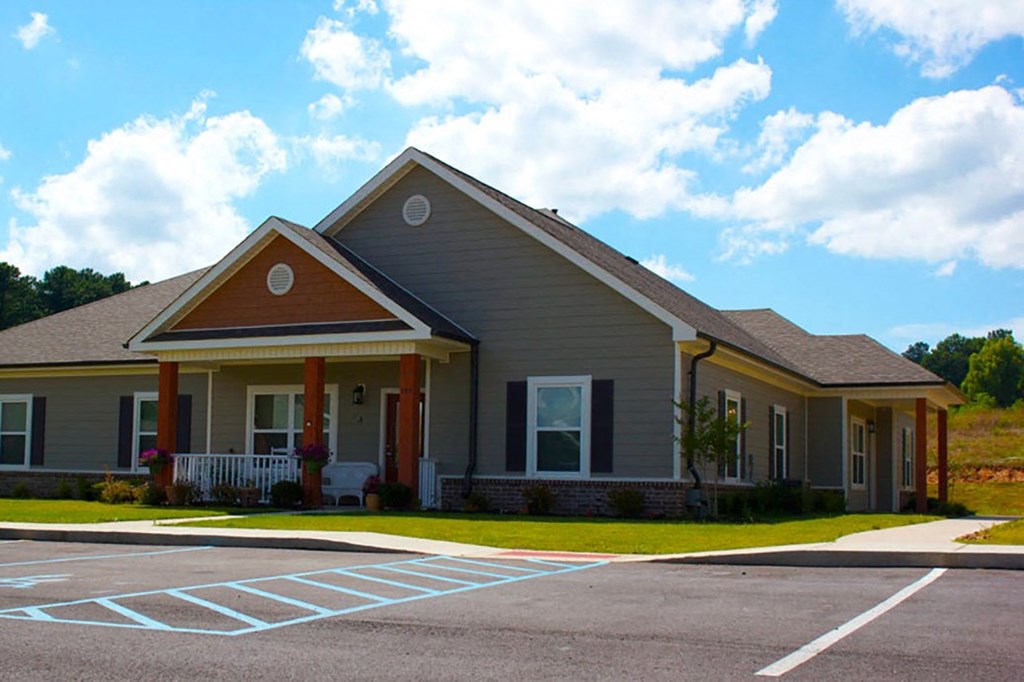 a large house with a porch and a parking lot