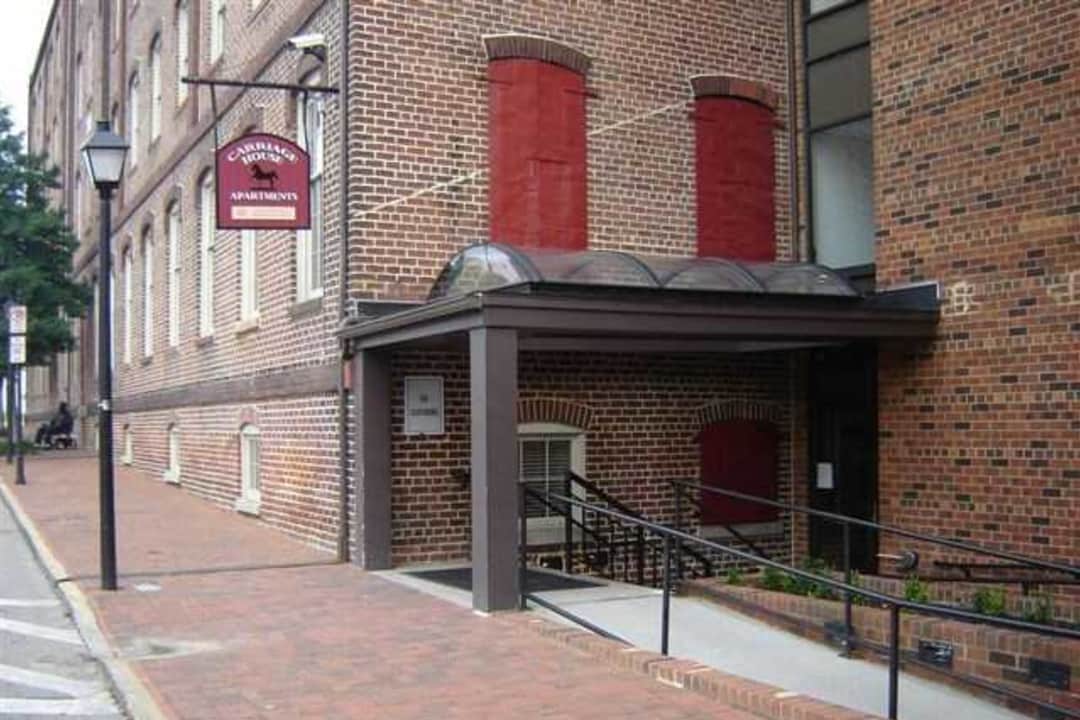 an old brick building with a black awning on the sidewalk