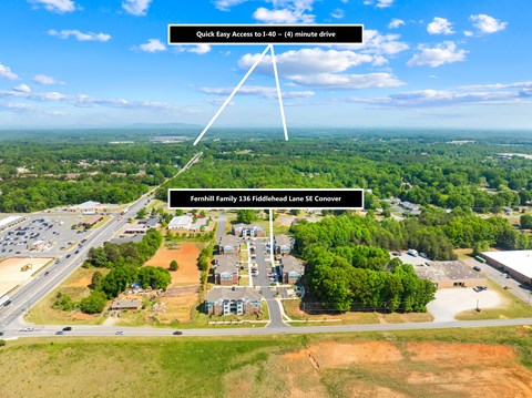 An aerial view of a construction site with a road leading to a building and a sign indicating a quick access to 40-60 minutes drive.