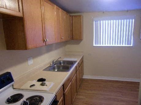 A kitchen with wooden cabinets and a white stove top.