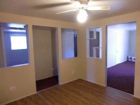 an empty living room with a ceiling fan