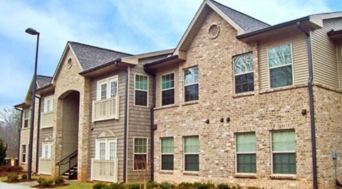 A large stone and siding house with a grey roof.