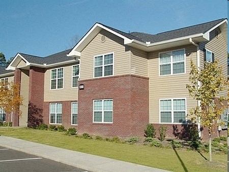 a large brick house with a sidewalk in front of it