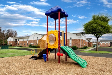 A playground with a yellow slide and a blue canopy.