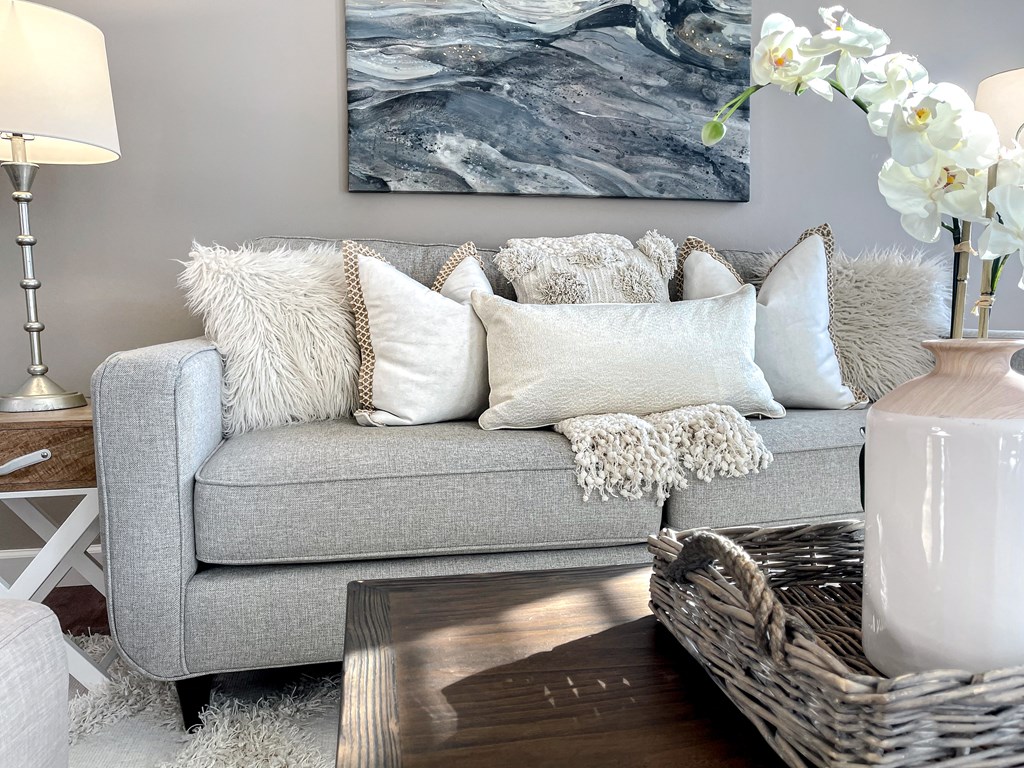 a living room with a gray couch and pillows