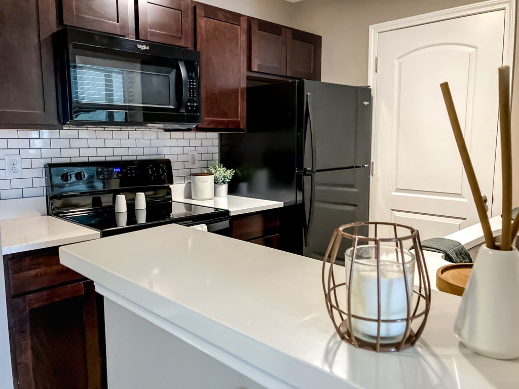 a kitchen with black appliances and a white counter top