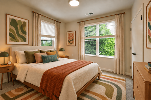 A bedroom with a large bed and a window overlooking a green area.