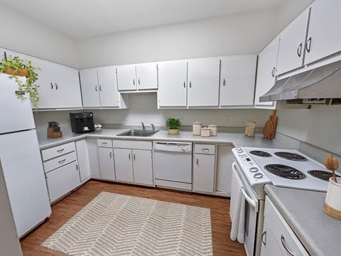 A kitchen with white cabinets and appliances.