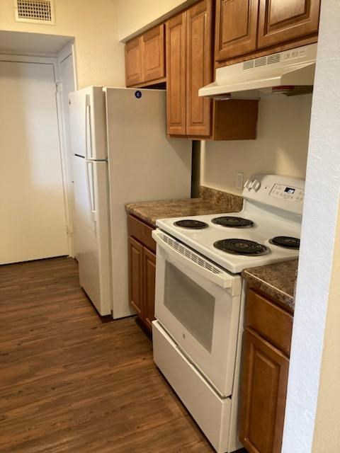 A kitchen with a white stove and white oven.
