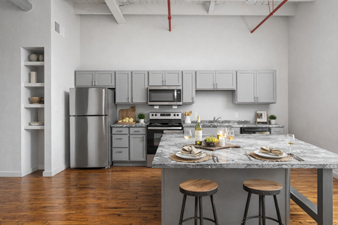 A modern kitchen with a marble countertop and wooden stools.