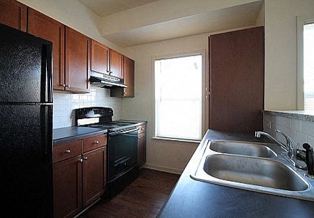 a kitchen with a sink a stove and a refrigerator