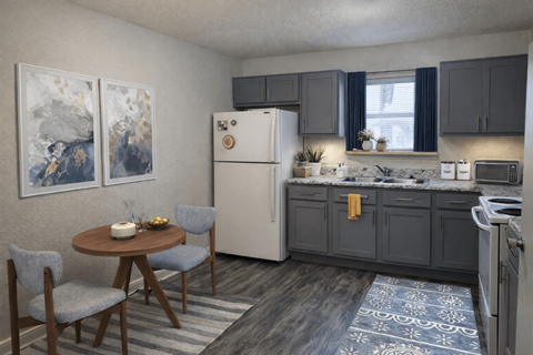 A kitchen with a refrigerator, table, and chairs.