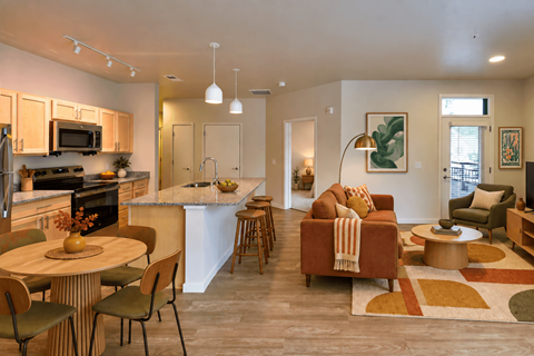A modern kitchen and living room with a dining table and chairs.