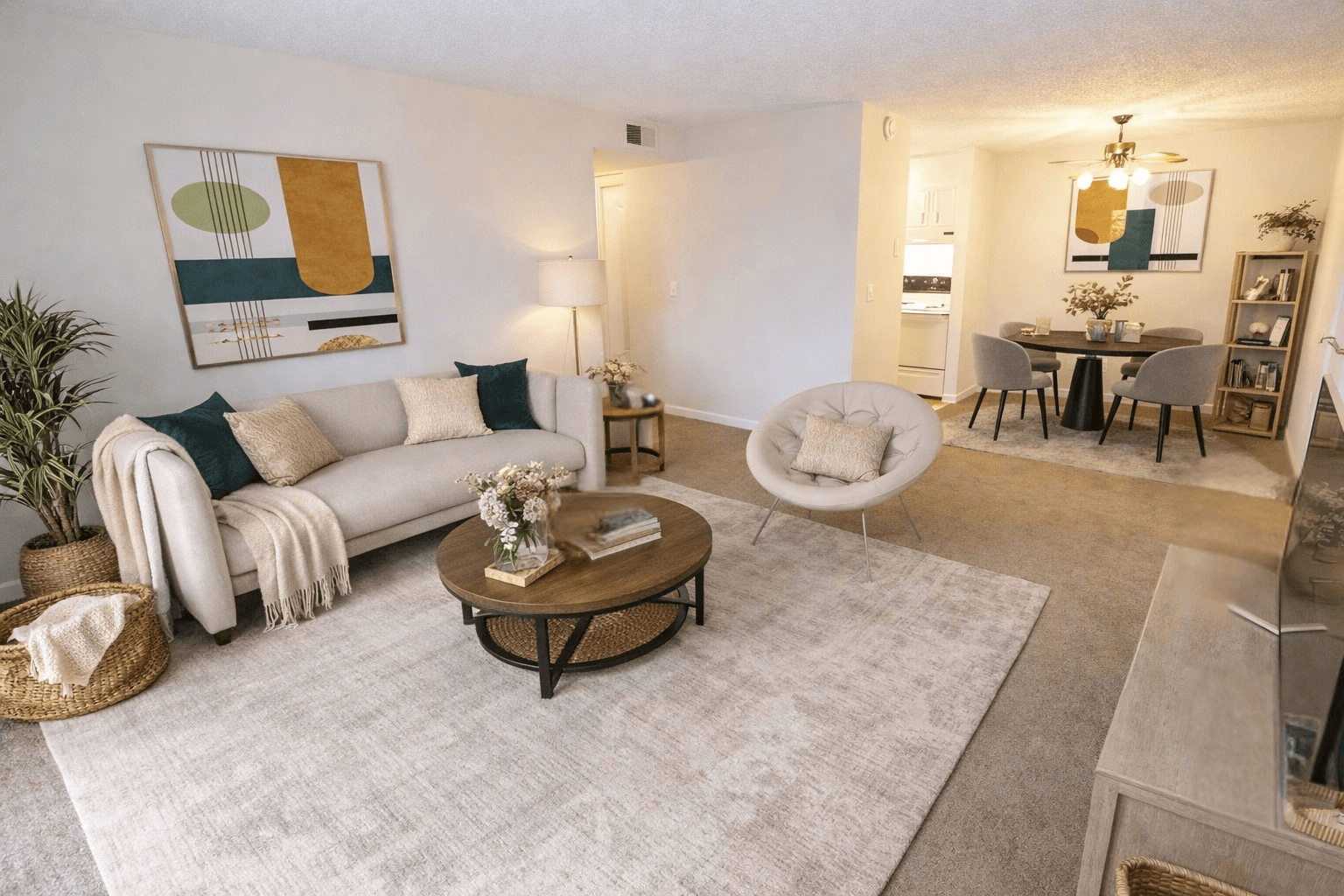 A living room with a white couch, a coffee table, and a painting on the wall.