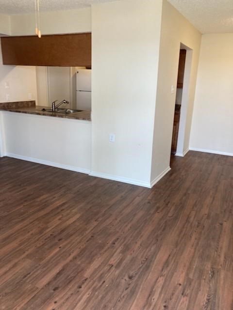 A room with wooden flooring and white walls.