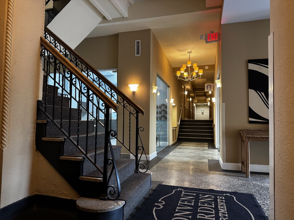 A lobby with a staircase and a sign that says Starbucks A lobby with a staircase and a sign that says Starbucks