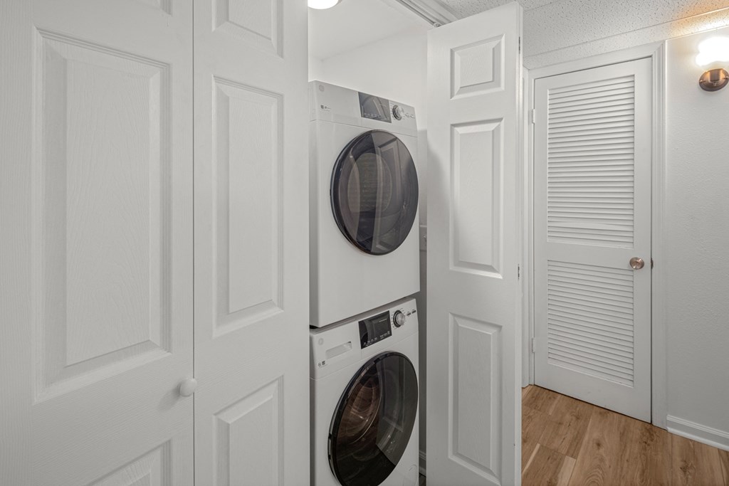 A white washing machine and dryer in a laundry room.at Mammoth at the Orchard Apartments, Rogers, AR 72756  