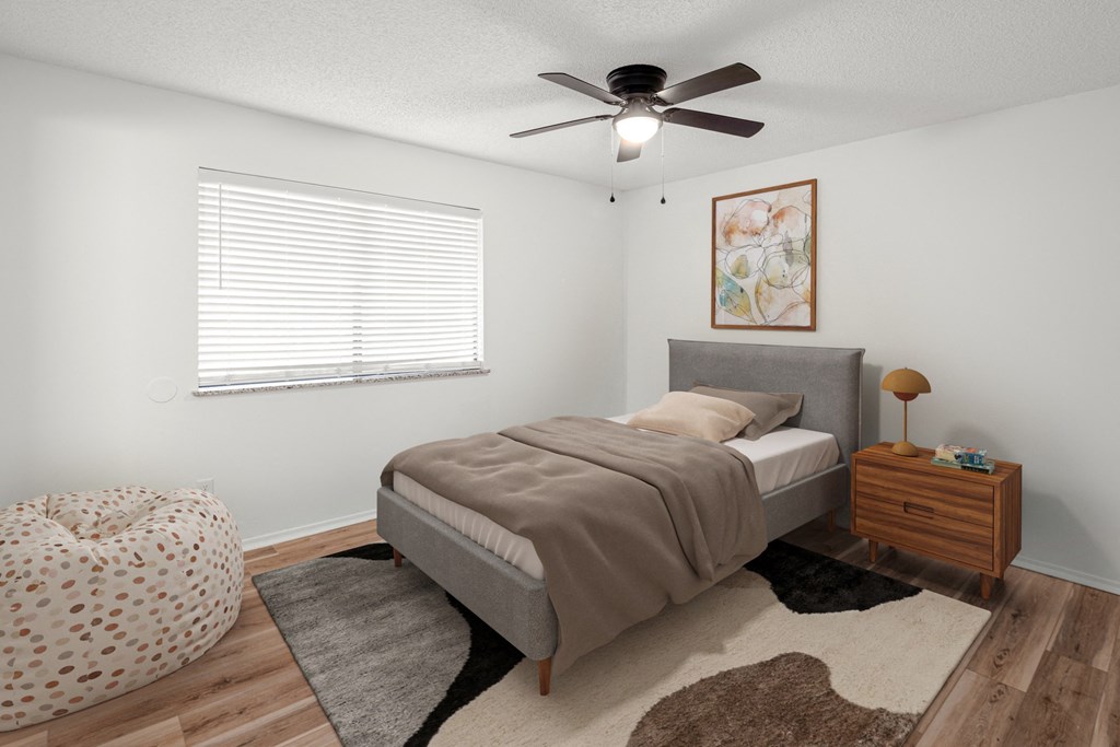 A bedroom with a bed, a ceiling fan, and a rug.at Mammoth at the Orchard Apartments, Rogers, AR  