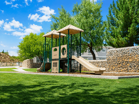 A playground with a slide and a swing set.