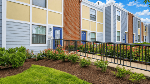 A row of townhouses with blue doors and windows.