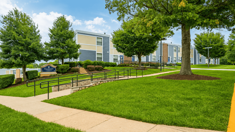 A tree in a grassy area in front of a building.