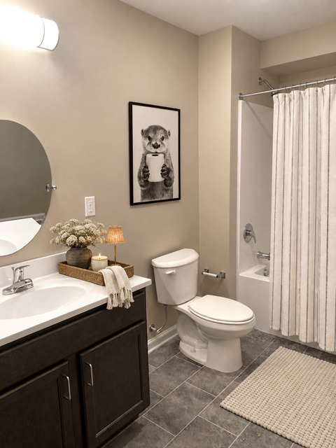 A bathroom with a toilet, sink, and a picture of a dog.