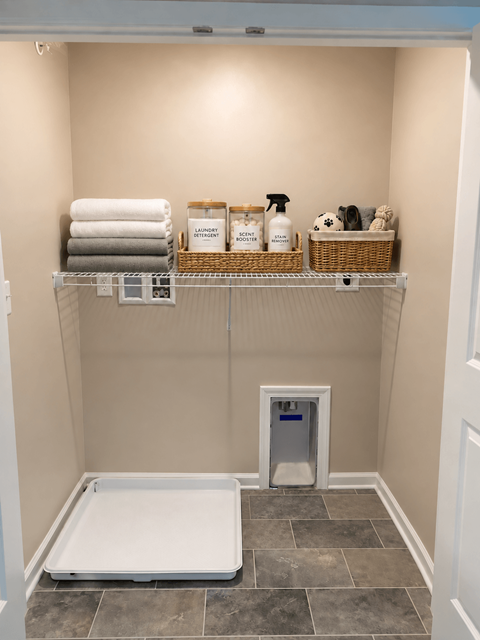 A bathroom with a white toilet and a white shelf with towels and cleaning supplies.