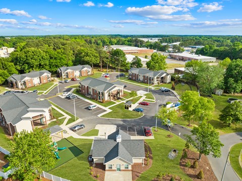 A bird's eye view of a residential area with houses and a parking lot.