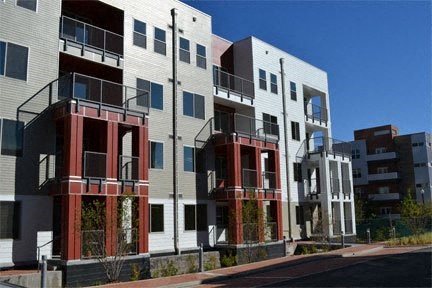 a row of apartment buildings on the side of a street