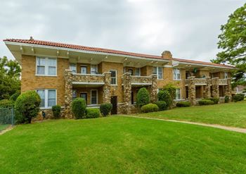 A large house with a red tile roof and stone pillars.