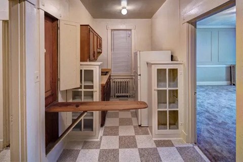 A kitchen with a checkered floor and a bench.