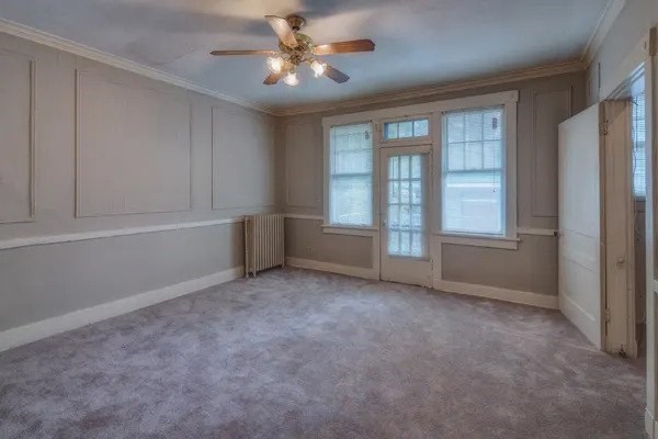 A room with a ceiling fan and a window.