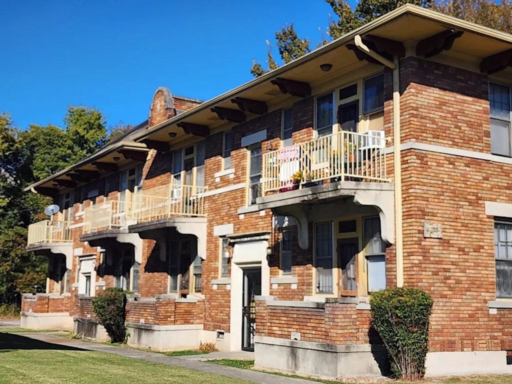 A red brick building with a balcony on the second floor.