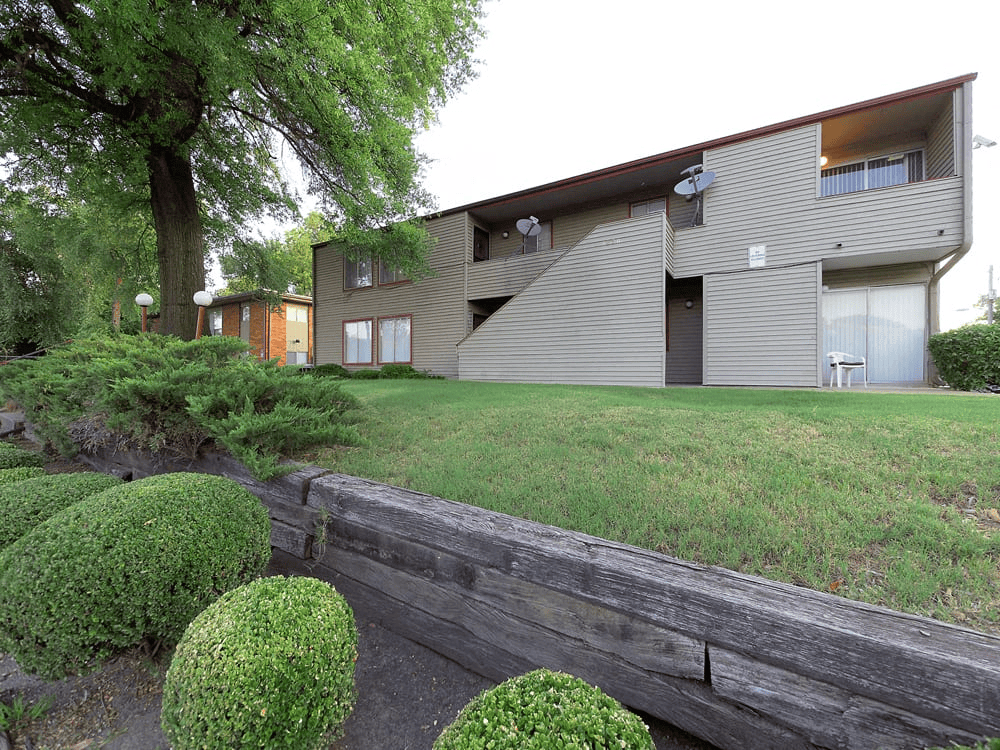 A modern house with a grey exterior and a wooden fence in front.