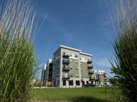 A modern apartment building with a grassy area in front.