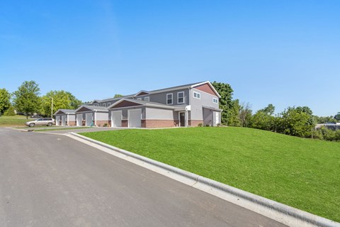 A row of houses with a car parked in front of the first one.