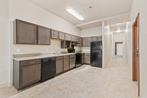 A kitchen with brown cabinets and black appliances.