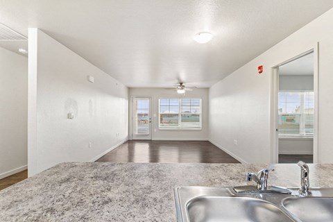 A spacious room with a sink and a ceiling fan.