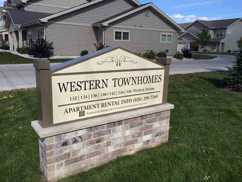 A sign for Western Townhomes in front of some houses.