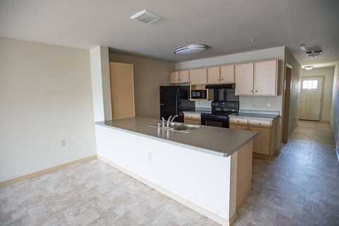 A kitchen with a black stove top oven and black microwave.
