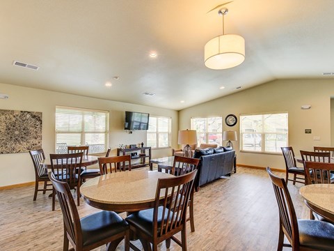 A large dining room with a round table and chairs.