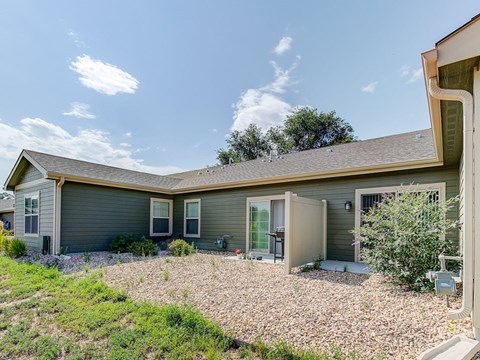 A house with a grey exterior and a brown roof.