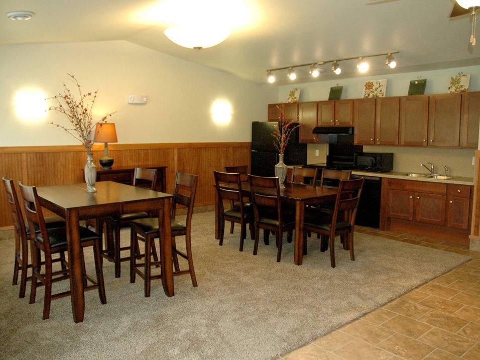 A kitchen with a table and chairs.