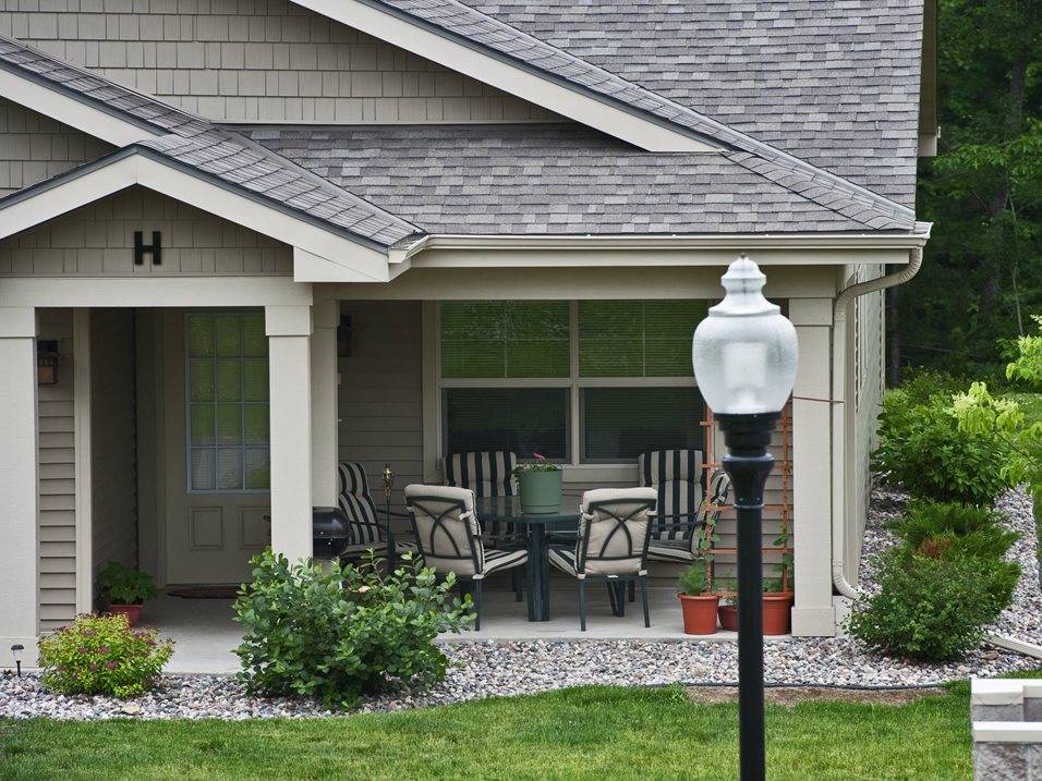 A house with a porch and a lawn.